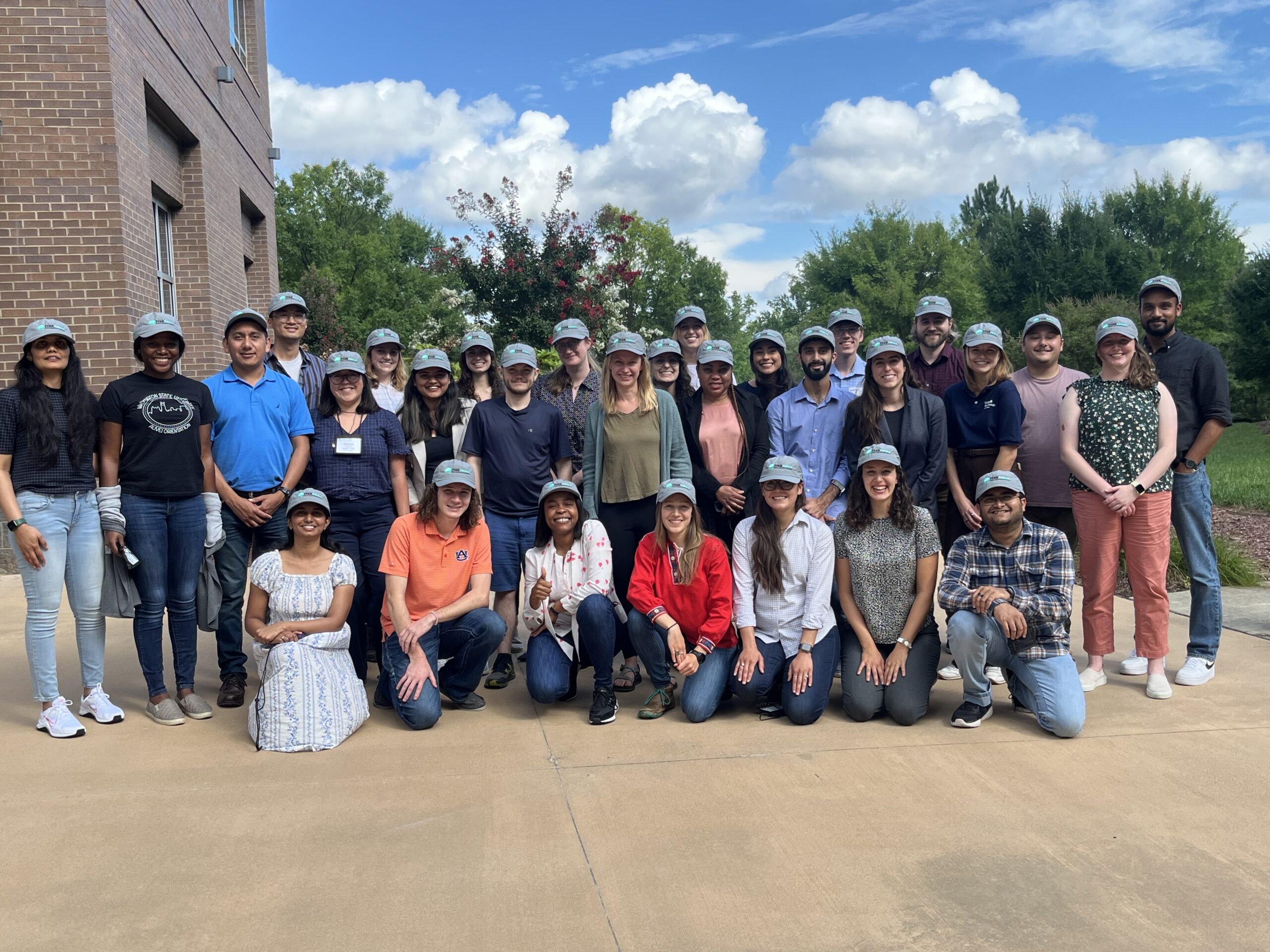 Graduate students gathered together on campus for a group photo.