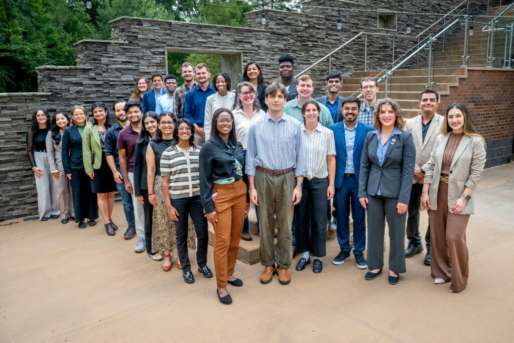 Graduate students gathered together on campus for a group photo.
