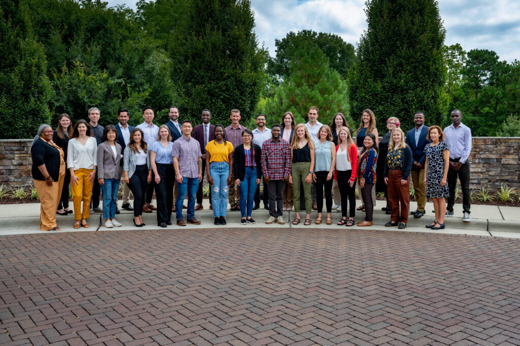 Graduate students gathered together on campus for a group photo.